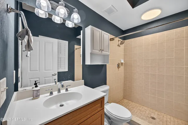 a bathroom with a sink toilet vanity and shower