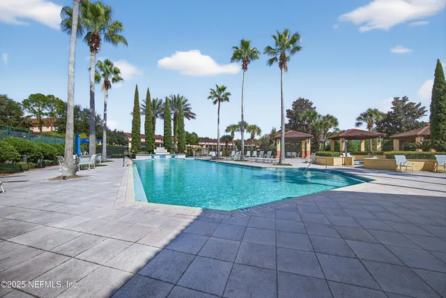 a view of a tennis ground with large trees