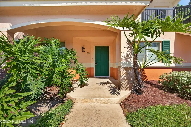 a potted plant sitting in front of a house with a garden