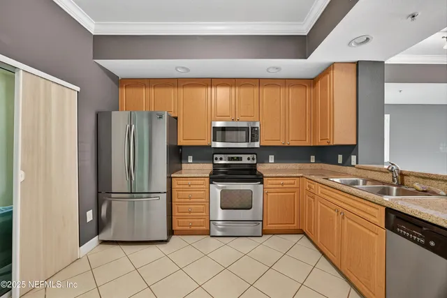 a kitchen with granite countertop a refrigerator and a sink