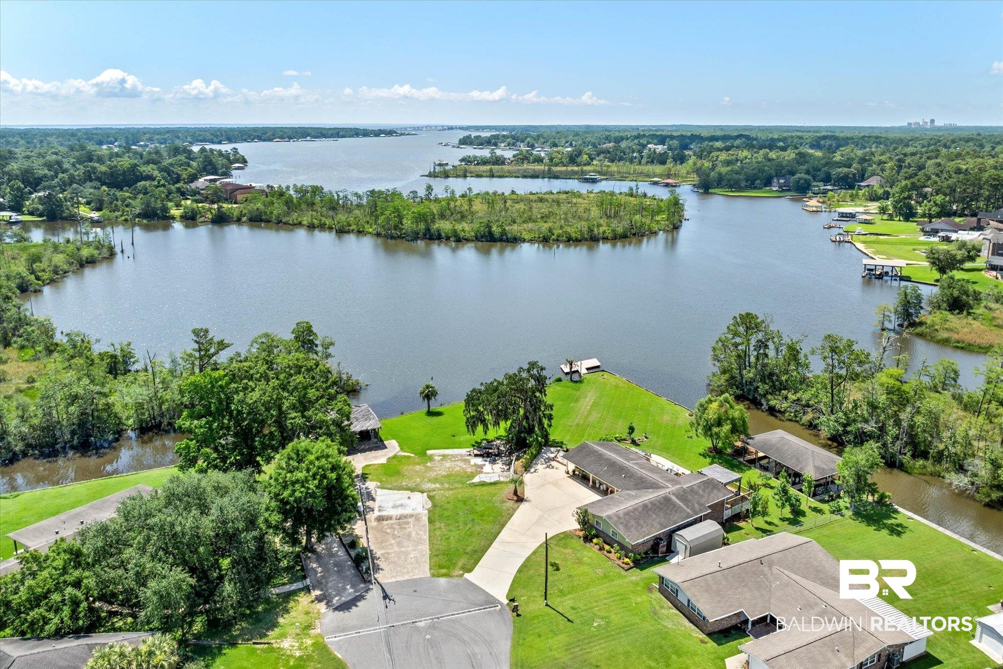 3801 Point Road Mobile, AL 36619 - Photo 1 of 55 Expansive waterfront property featuring a private boat dock, lush green lawn, mature trees, and direct water access