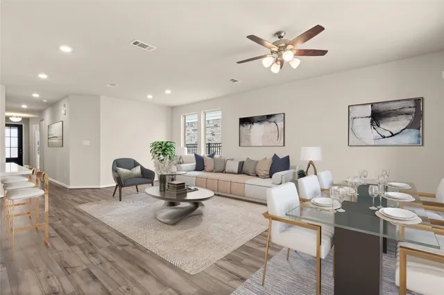a living room with furniture a chandelier and a dining table