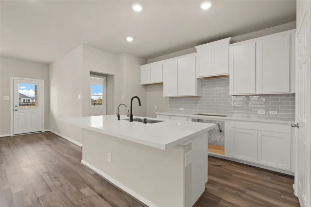 a kitchen with a sink cabinets and wooden floor
