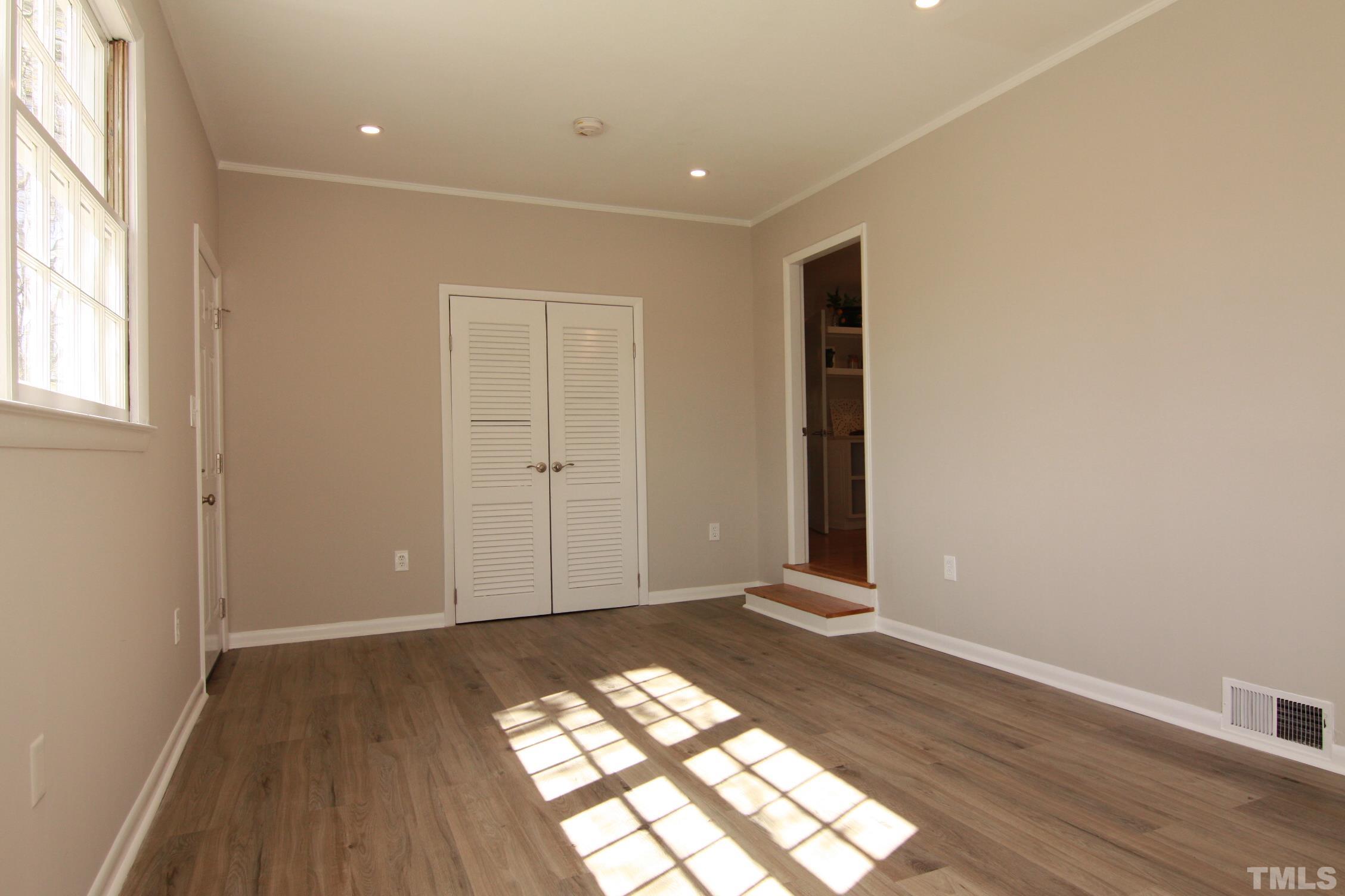 1503 Sedwick Road Durham, NC 27713 - Photo 16 of 33 an empty room with wooden floor and windows