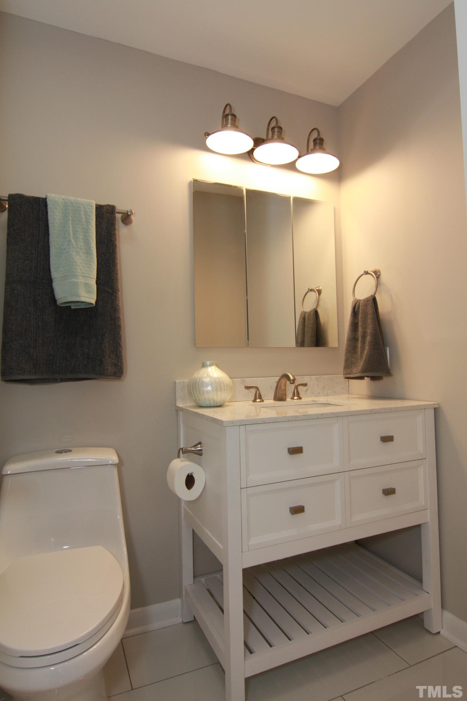 1503 Sedwick Road Durham, NC 27713 - Photo 20 of 33 a bathroom with a sink mirror and vanity