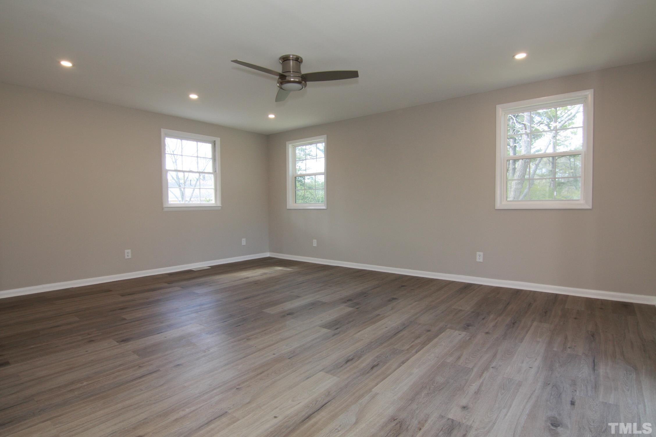 1503 Sedwick Road Durham, NC 27713 - Photo 26 of 33 an empty room with wooden floor fan and windows