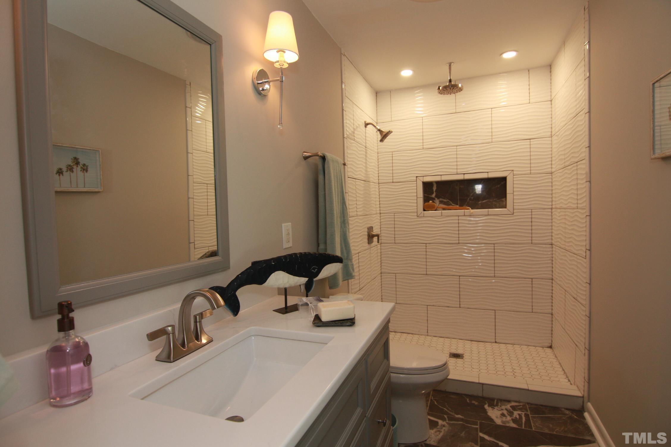 1503 Sedwick Road Durham, NC 27713 - Photo 28 of 33 a bathroom with a sink a toilet and shower