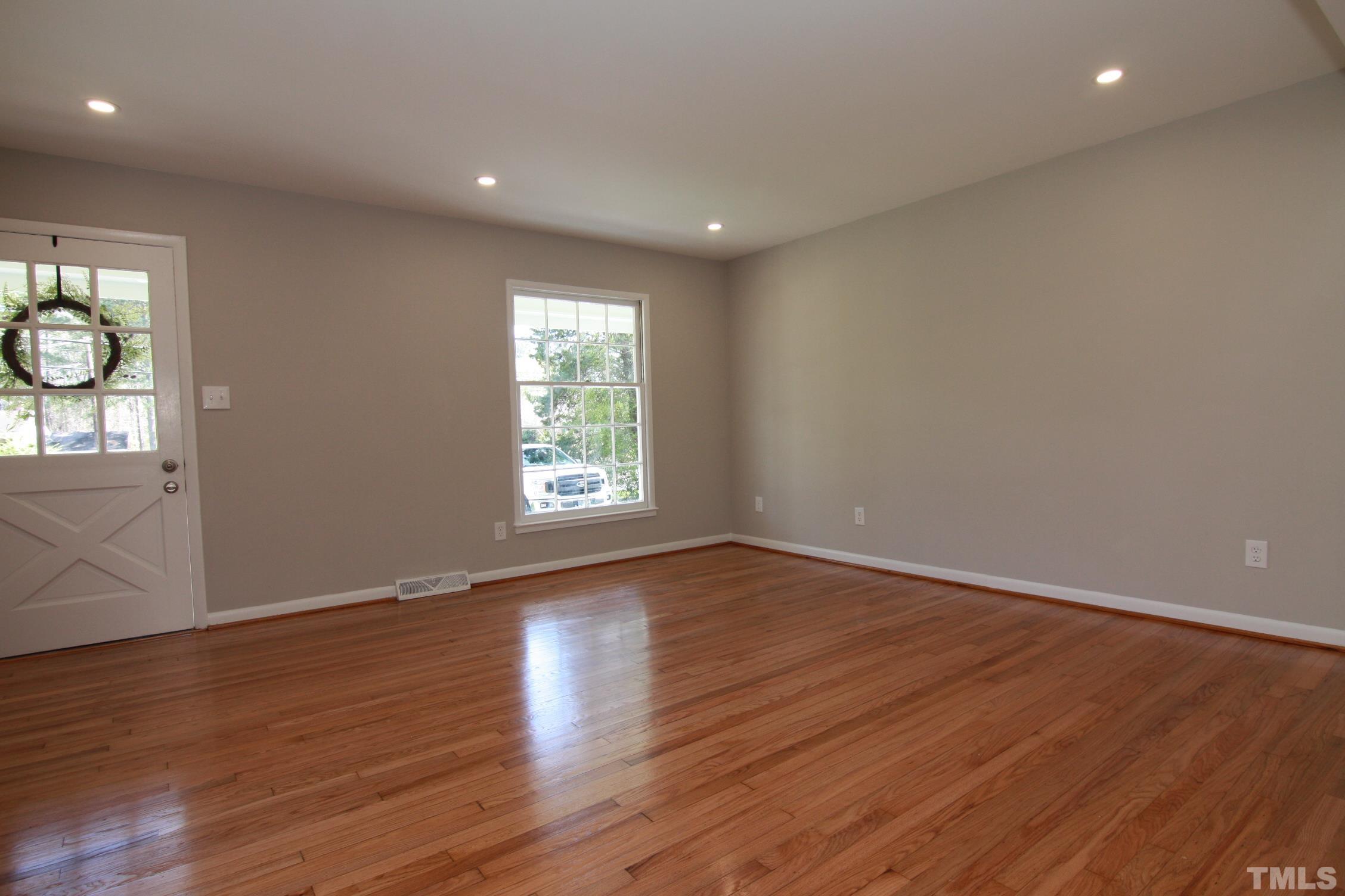 1503 Sedwick Road Durham, NC 27713 - Photo 7 of 33 an empty room with wooden floor and windows