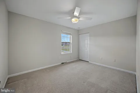 a bedroom with a large bed and paintings on the wall