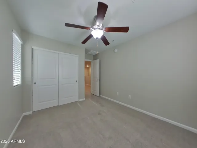 an empty room with chandelier fan