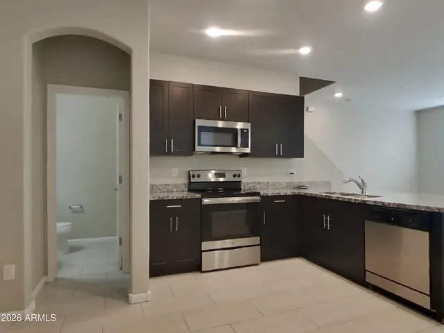 a kitchen with granite countertop a sink and cabinets