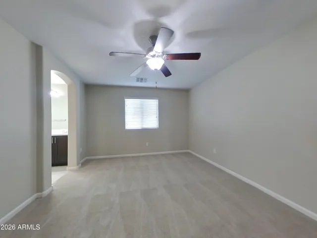 a view of a refrigerator in kitchen and an empty room