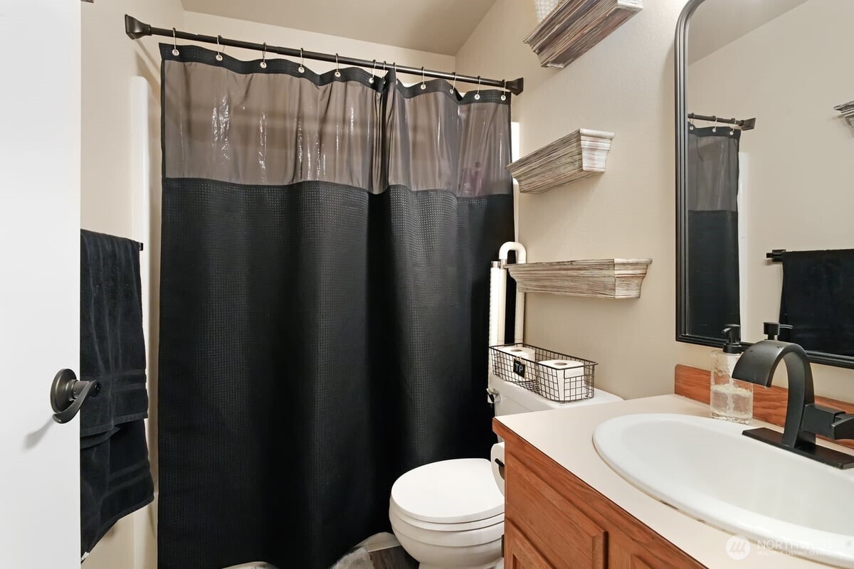 25 Clemons Road Montesano, WA 98563 - Photo 14 of 32 a bathroom with a sink a toilet a mirror and shower curtain