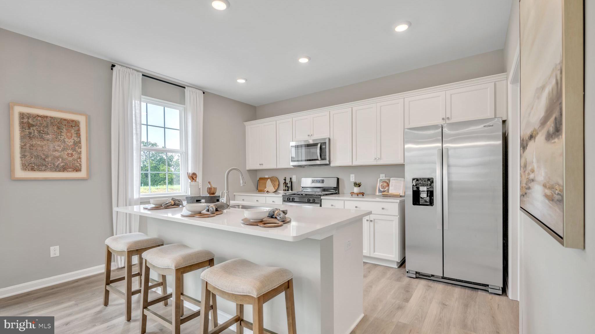 121 Winding Road Easton, PA 18040 - Photo 19 of 24 a kitchen with a refrigerator a sink dishwasher and white cabinets with wooden floor
