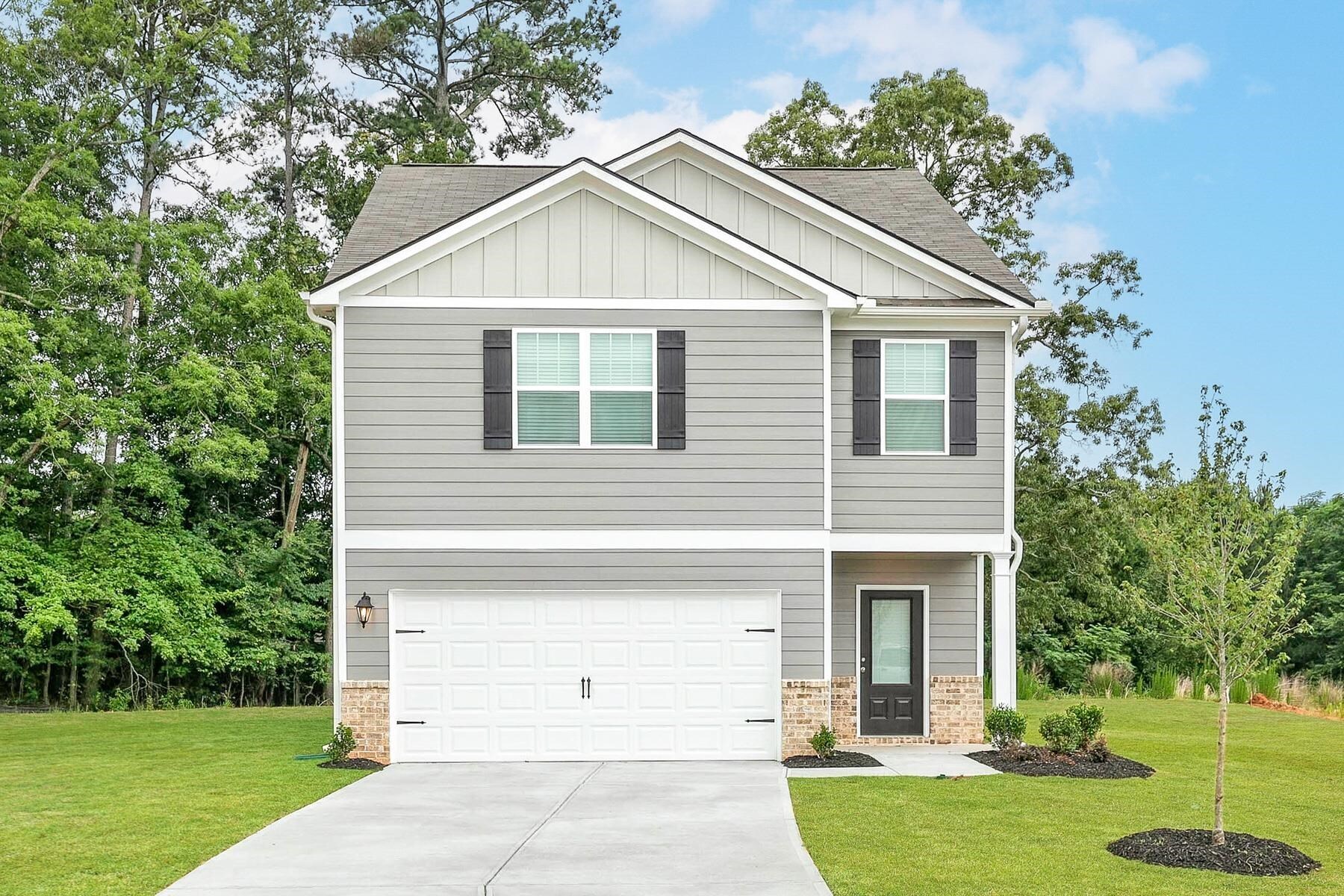 a view of a white house next to a yard with big trees