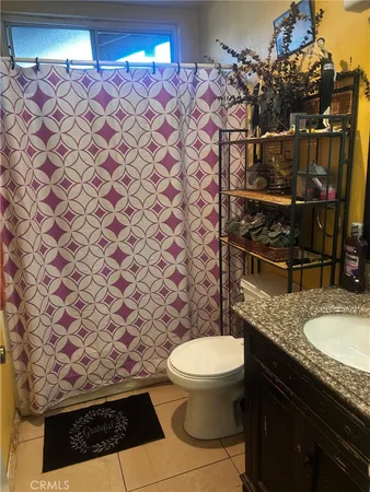 a bathroom with a granite countertop toilet and a sink