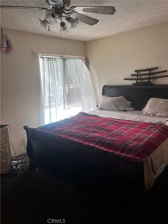 a bedroom with a bed and dresser with wooden floor