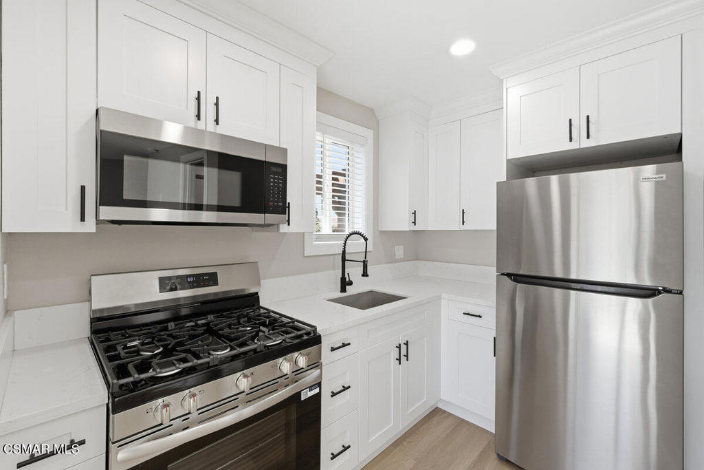 1069 Donner Avenue, Unit B Simi Valley, CA 93065 - Photo 5 of 7 a kitchen with refrigerator a microwave a sink and cabinets
