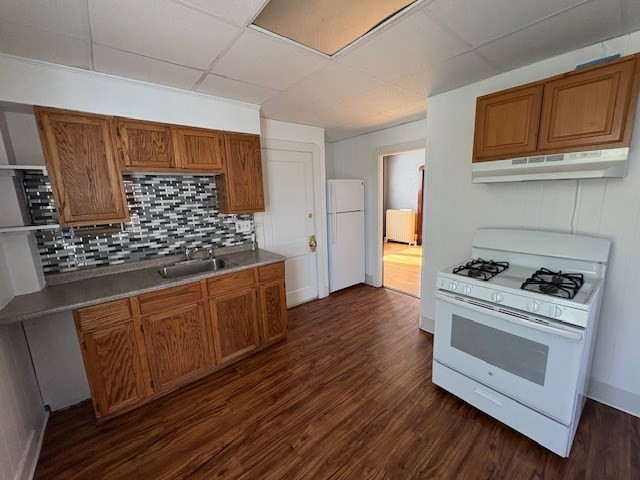 a kitchen with wooden floors and white appliances