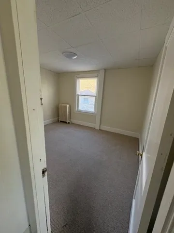 an empty room with a window and a hallway