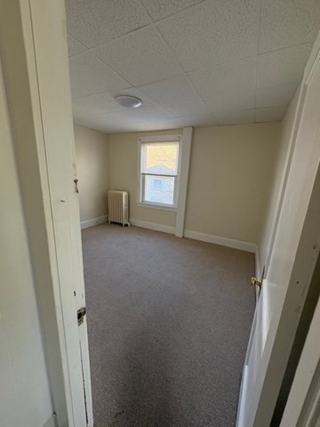967 Robeson Street, Unit 2 Fall River, MA 02720 - Photo 10 of 15 an empty room with a window and a hallway