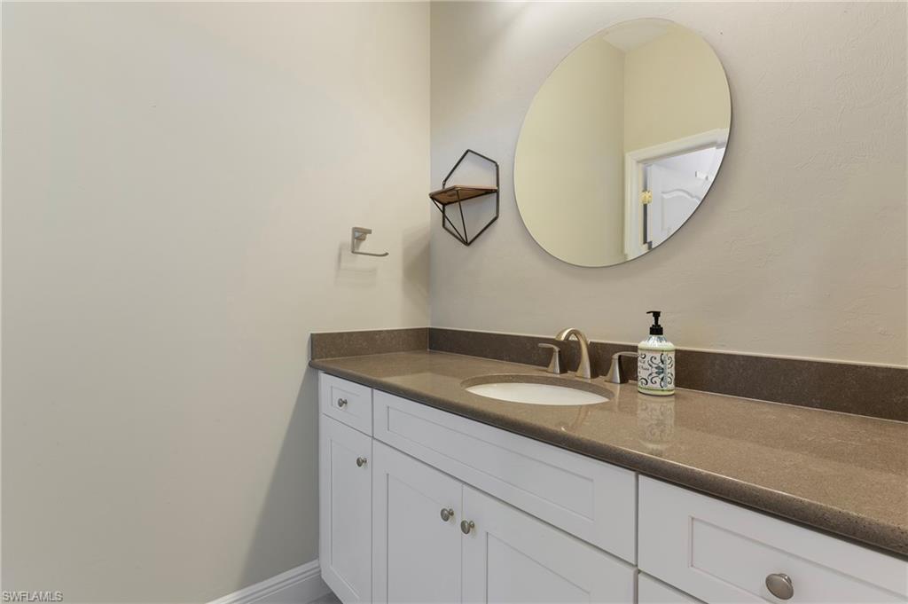 6954 Avalon Circle, Unit 706 Naples, FL 34112 - Photo 22 of 26 a bathroom with a granite countertop sink and a mirror
