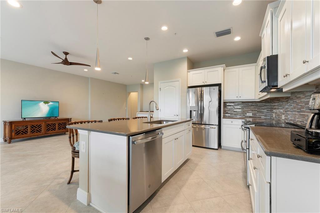 6954 Avalon Circle, Unit 706 Naples, FL 34112 - Photo 8 of 26 a kitchen with stainless steel appliances granite countertop a sink stove and refrigerator
