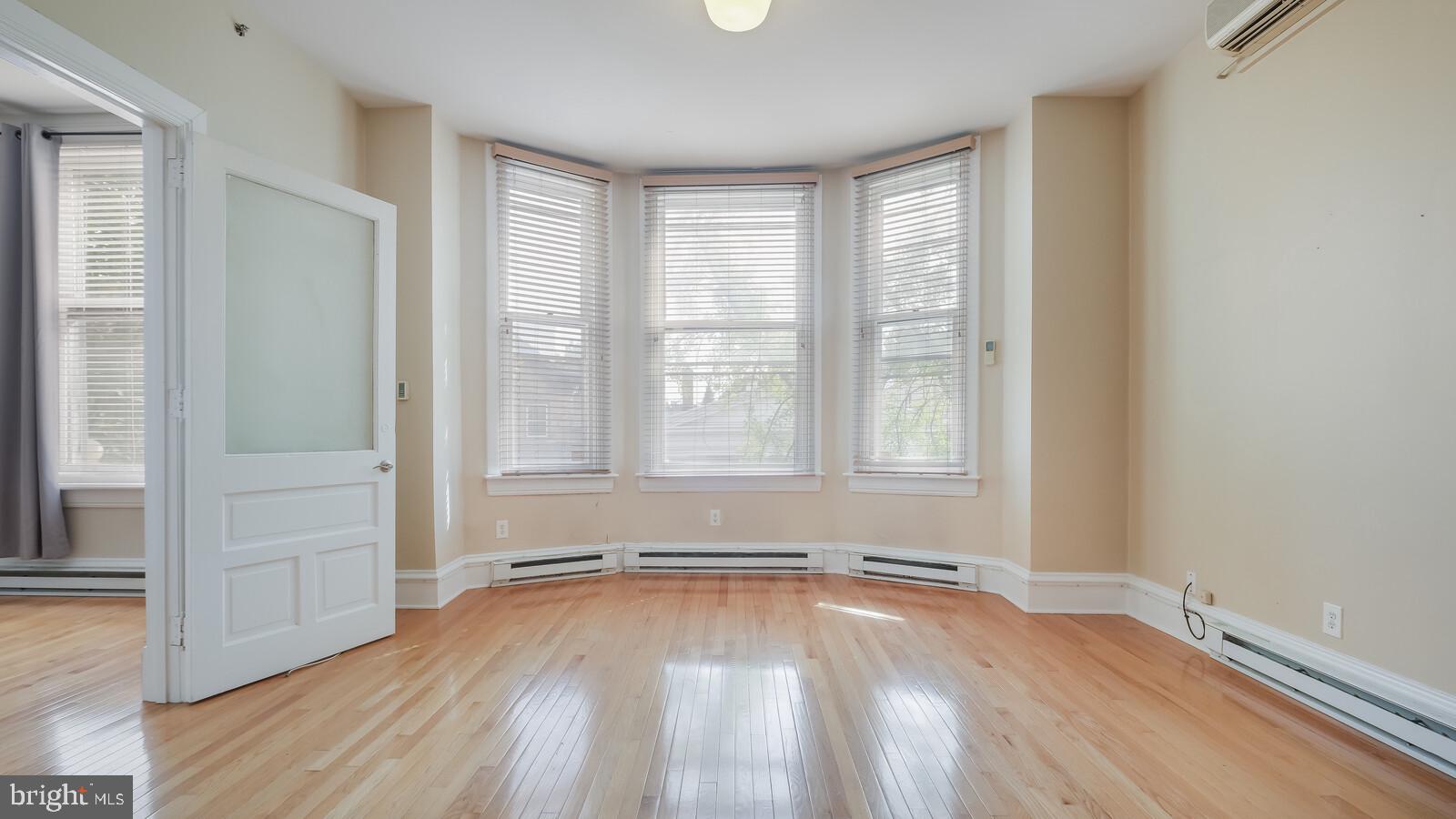 22 North Main Street, Unit 3 Doylestown, PA 18901 - Photo 12 of 18 an empty room with wooden floor and windows