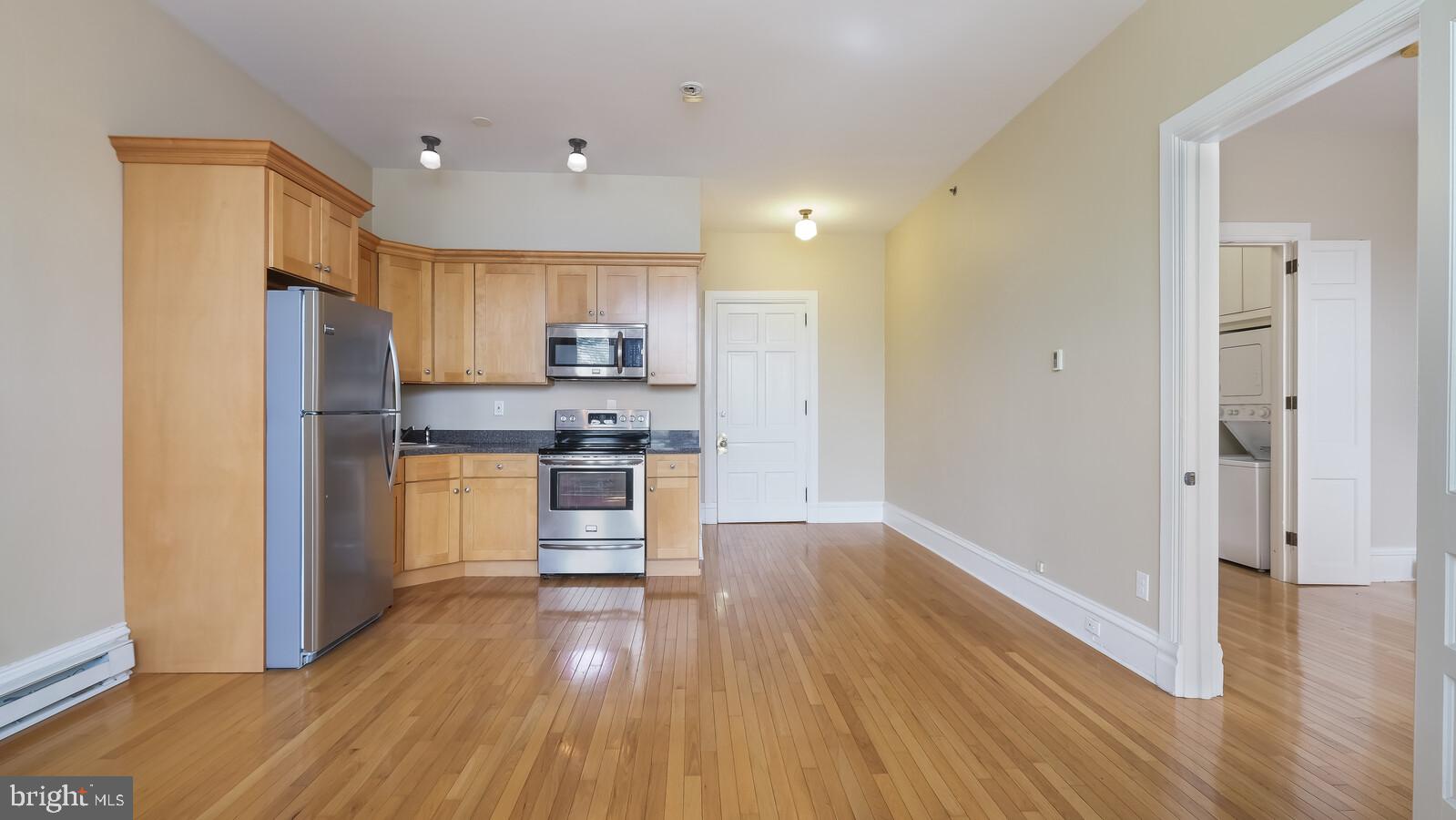 22 North Main Street, Unit 3 Doylestown, PA 18901 - Photo 8 of 18 a kitchen with kitchen island wooden floors appliances and cabinets