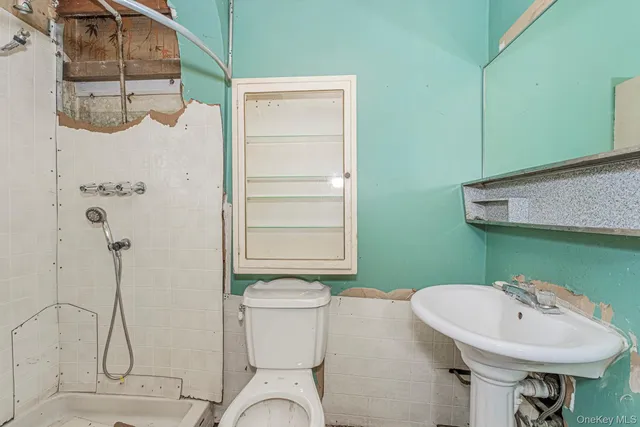 a bathroom with a granite countertop bathtub sink vanity mirror and toilet