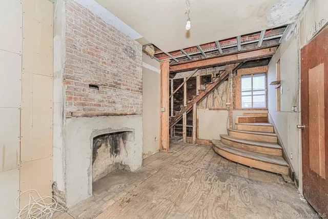 a view of a livingroom with wooden floor and a fireplace