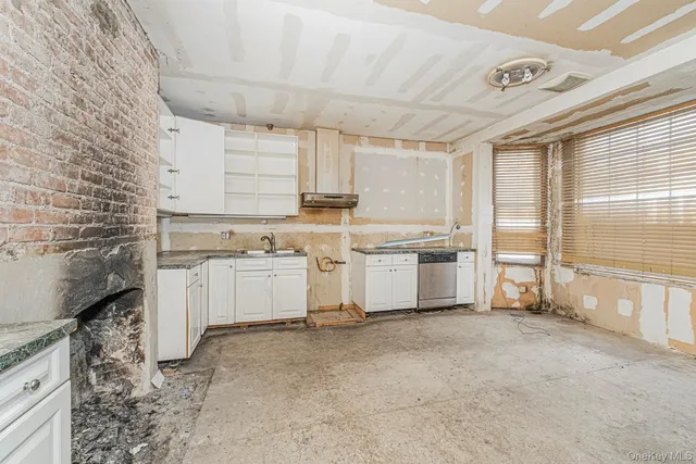 a kitchen with white cabinets stove and white kitchen