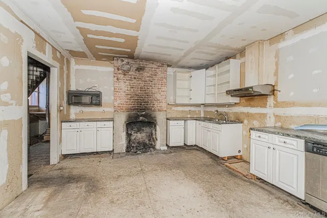 a kitchen with white cabinets and appliances