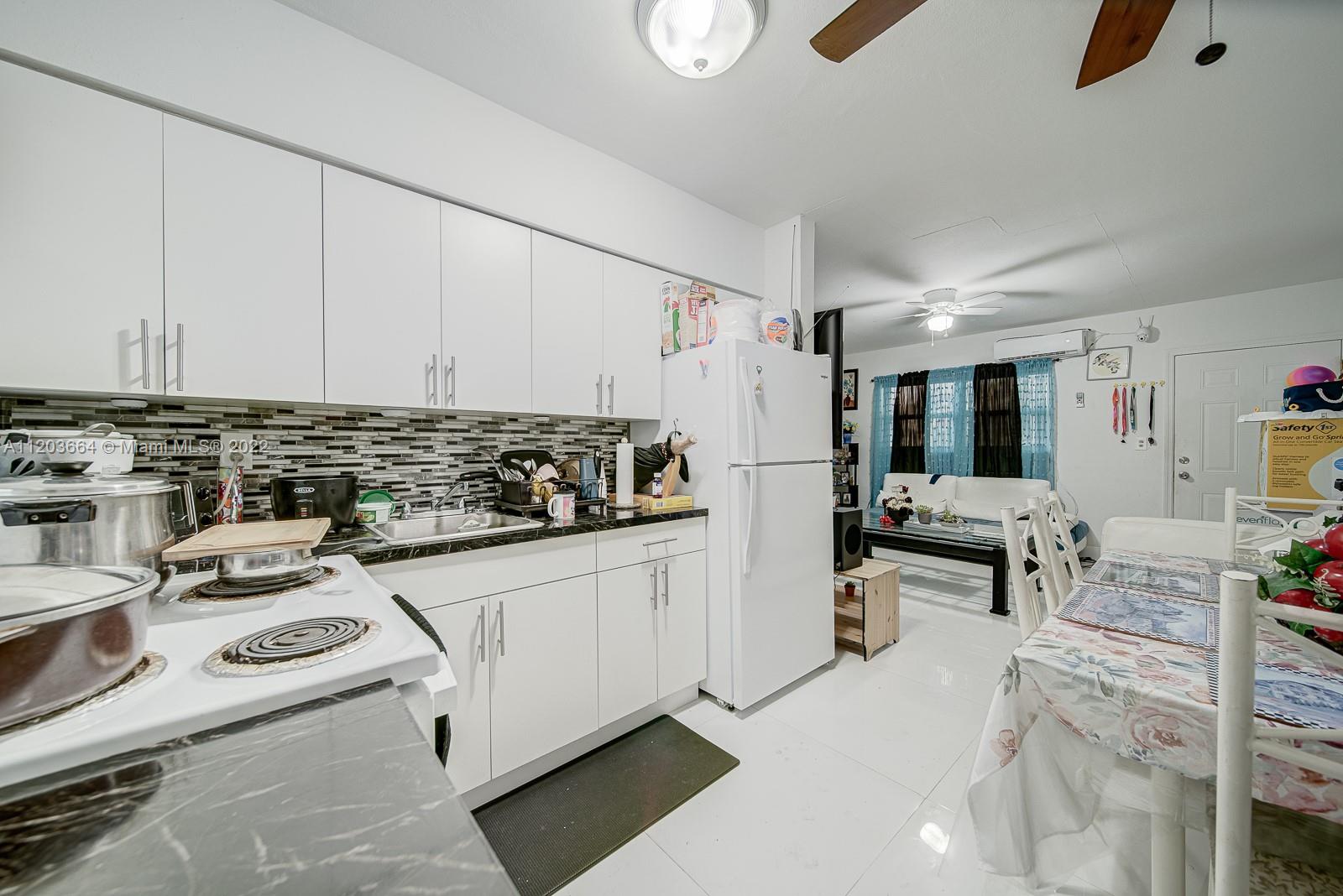 1920 Southwest 4th Street Miami, FL 33135 - Photo 11 of 28 a kitchen with a sink a stove and white cabinets