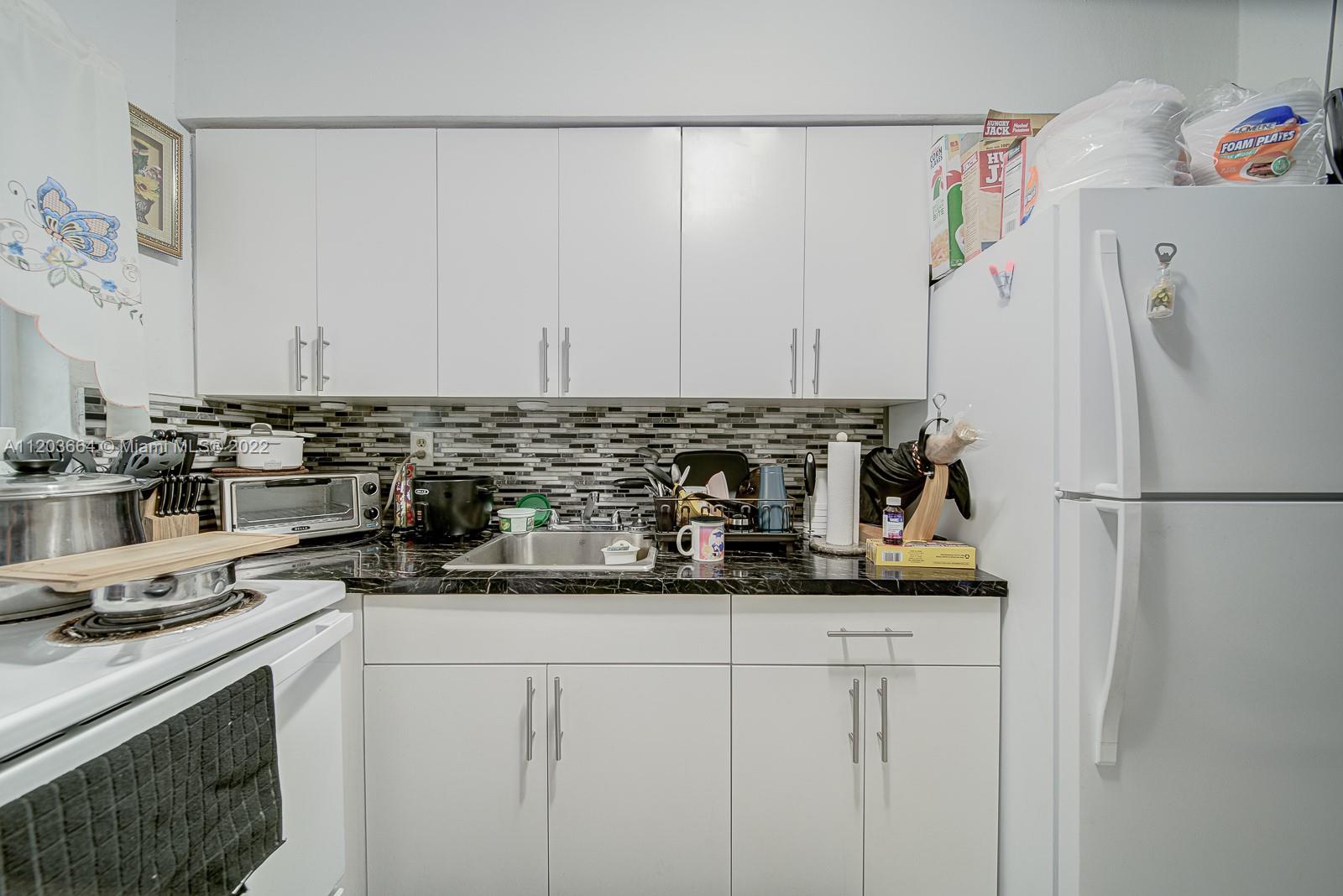 1920 Southwest 4th Street Miami, FL 33135 - Photo 12 of 28 a kitchen with a sink a stove and refrigerator