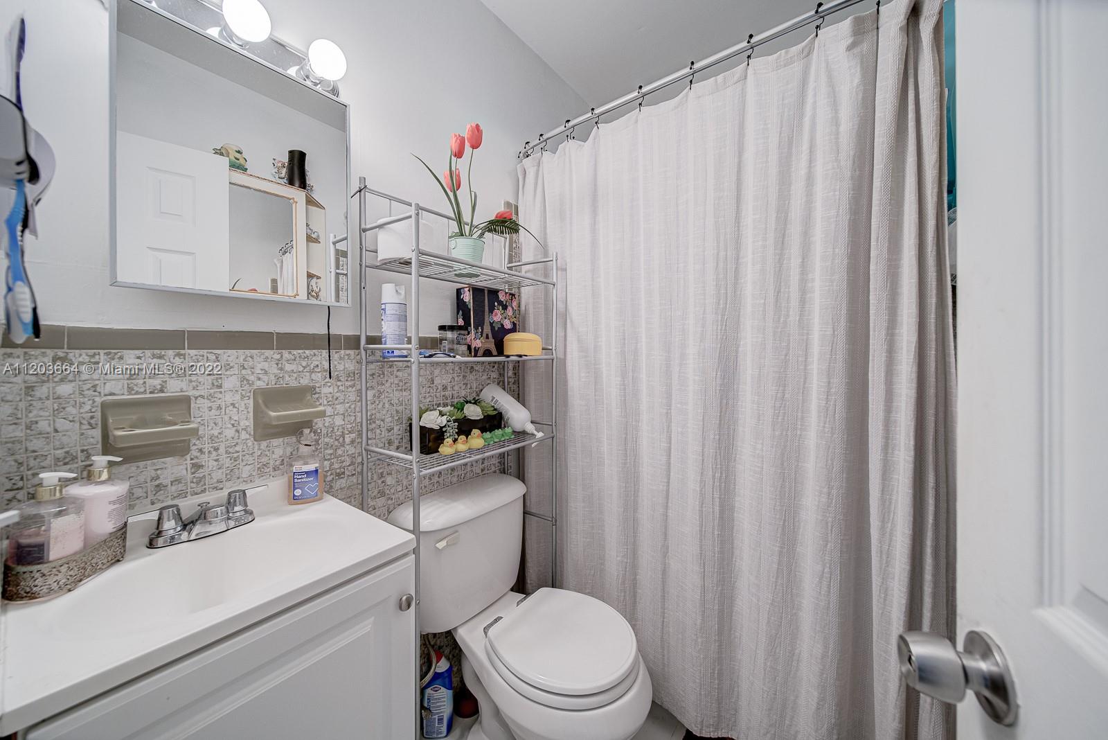1920 Southwest 4th Street Miami, FL 33135 - Photo 15 of 28 a bathroom with a sink a toilet and shower curtain