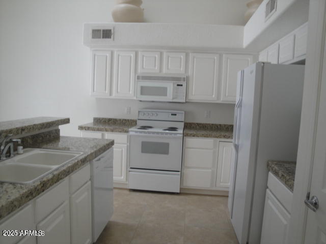 7461 West Matilda Lane Glendale, AZ 85308 - Photo 4 of 18 a kitchen with white cabinets and white appliances