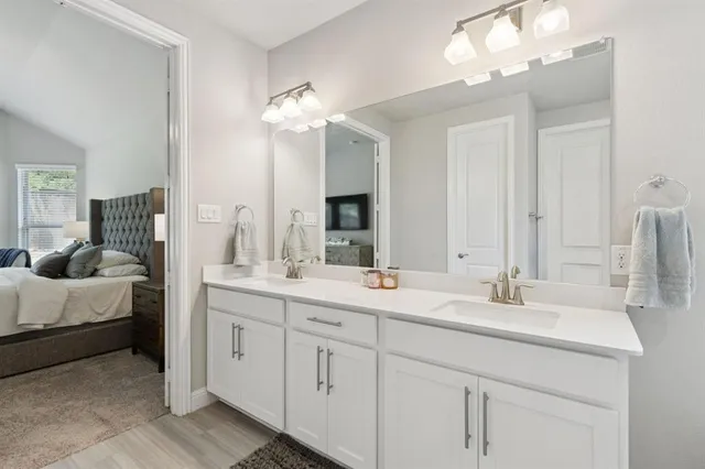 a en suite bathroom with double vanity a sink and a mirror