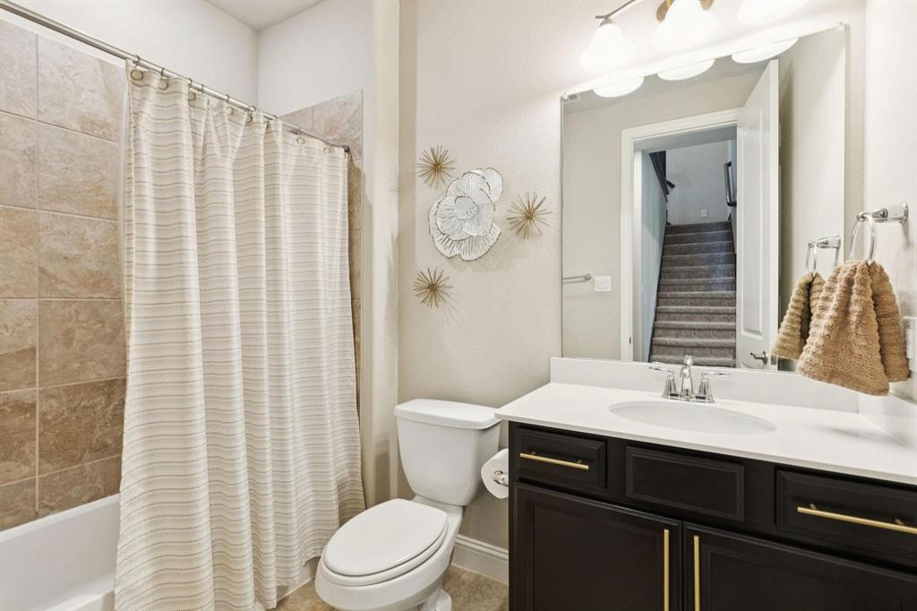 2121 Demarsh Lane Corinth, TX 76210 - Photo 27 of 39 a bathroom with a sink a toilet and shower curtain