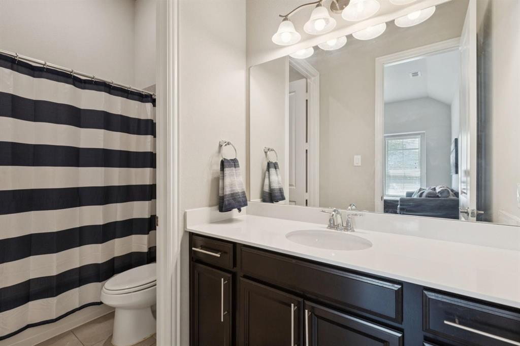 2121 Demarsh Lane Corinth, TX 76210 - Photo 31 of 39 a bathroom with a sink a toilet a mirror and shower curtain