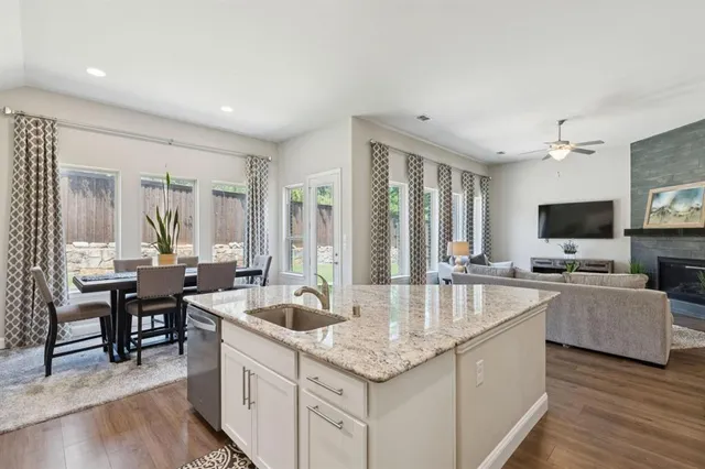 a large kitchen with sink a counter top space and living room