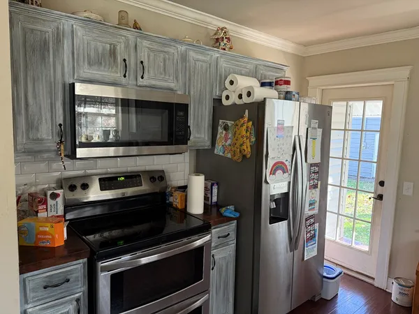 a kitchen with stainless steel appliances granite countertop a refrigerator and a stove top oven