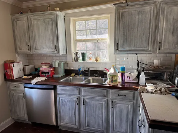a kitchen with granite countertop a sink stove and cabinets