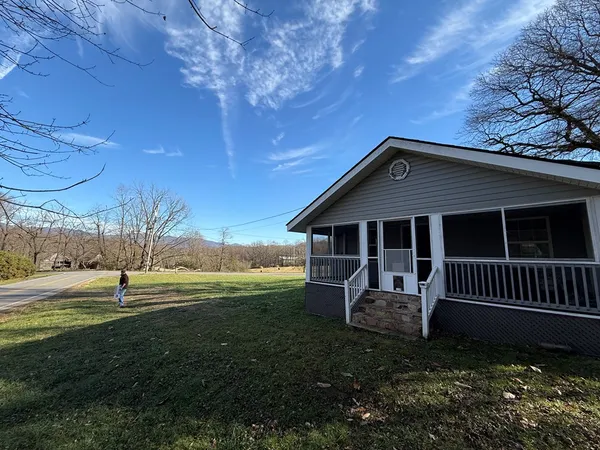 a view of a house with a yard and fence