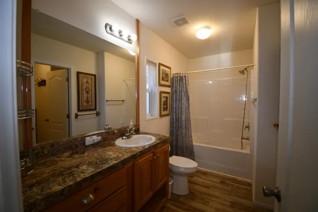 a bathroom with a granite countertop sink toilet and shower