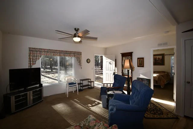 a living room with furniture a flat screen tv and a large window