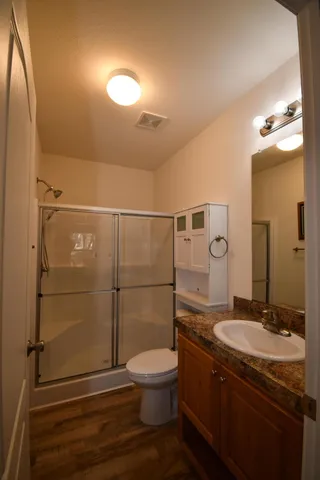 a bathroom with a granite countertop toilet sink and shower