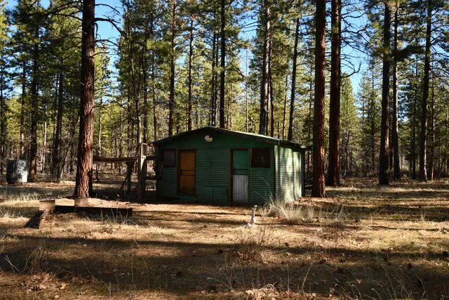 a backyard of a house with barbeque oven table and chairs
