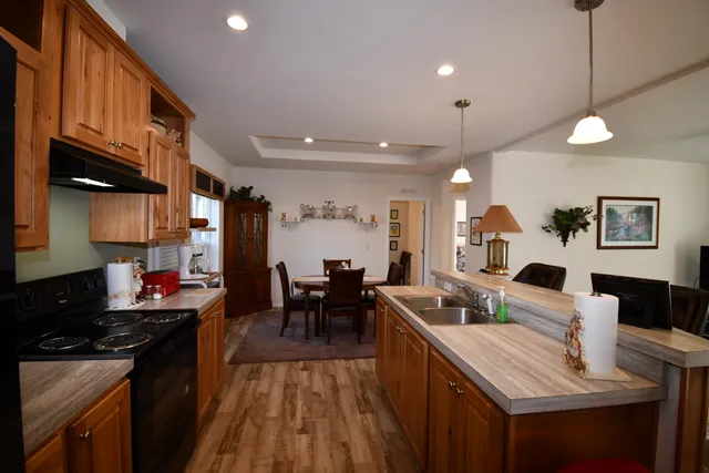 a kitchen with stainless steel appliances granite countertop a sink stove and wooden cabinets