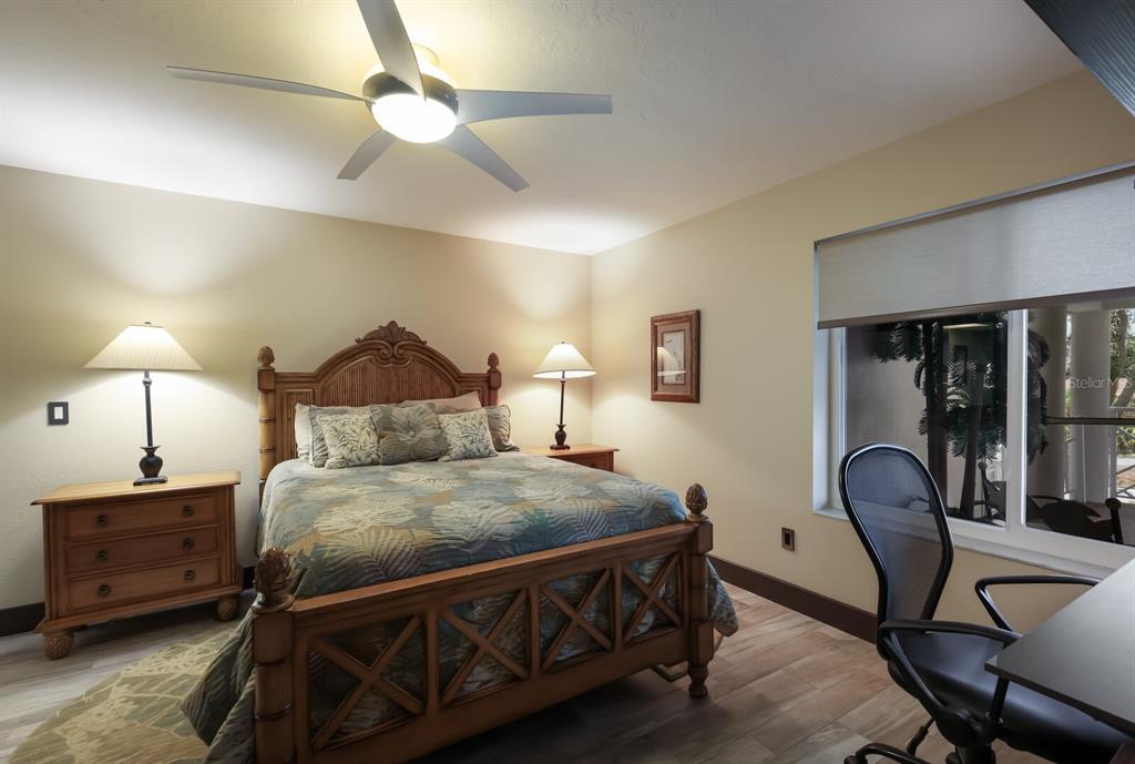 11000 Placida Road, Unit 2203 Placida, FL 33946 - Photo 25 of 64 a bedroom with a bed a lamp and a chandelier